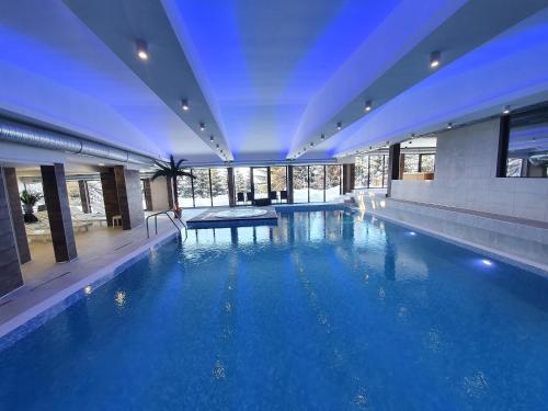 Una gran piscina con agua azul en un edificio. en Apartment Magic snow, en Kopaonik