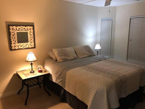 a bedroom with a bed and a table with two lamps at Golfer’s Paradise 3/2 Luxury Vacation Home in Bradenton