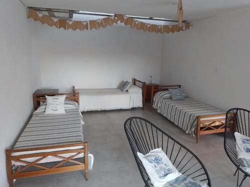 a room with two beds and two chairs in it at Quinta EL SECRETO in Olavarría