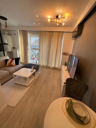 ein Wohnzimmer mit einem Sofa und einem Tisch in der Unterkunft Boutique Apartment in Bukarest