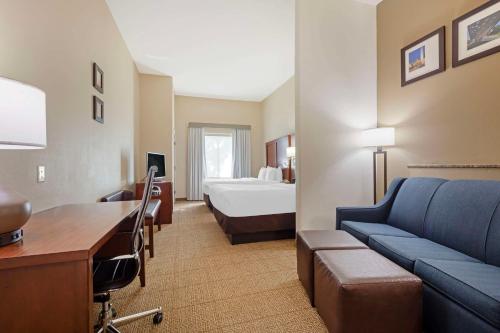 ダラスにあるComfort Suites West Dallas - Cockrell Hillのベッドとソファ付きの広いホテルルームです。