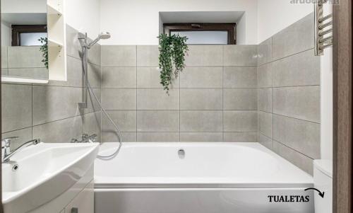 uma casa de banho com uma banheira branca e um lavatório. em Spacious Townhouse with Terrace and Parking em Vilnius