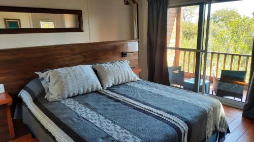 1 dormitorio con 1 cama y vistas a un balcón en Nairandey en La Pedrera