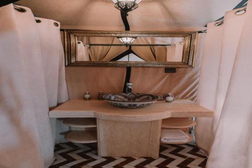 a bathroom with a sink and a mirror at desert camp in Adrouine