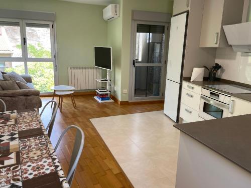een keuken en een woonkamer met een bank en een tafel bij Apartamento Rural El Estrecho de Arguedas in Arguedas