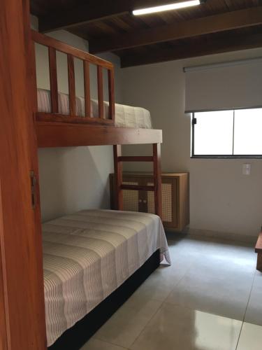 a bedroom with a bunk bed and a window at Chalé vista da serra in Delfinópolis