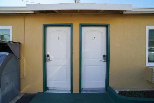 two doors on a house with numbers on them at SIGNAL HILL MOTEL BEACH MOTEL in Long Beach