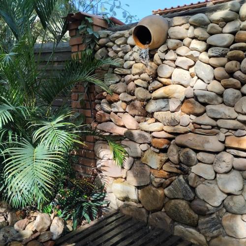 a stone wall with a potted plant on it at Sítio Estrela da Manhã Hospedagem e Lazer in Palmeiras