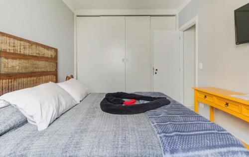 a bedroom with a bed with a black oar on it at Flat botique Guarujá in Guarujá