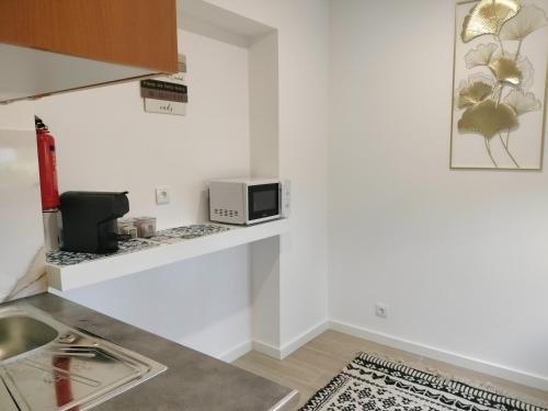a kitchen with a sink and a microwave at Alojamento Andorinhas in Senhora da Hora