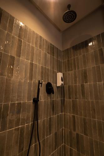 a tiled bathroom with a shower with a hose at TWENTY SIX ANFA LUXURY RESIDENCE by Shortstaymaroc -Hyper Centre -Parking in Casablanca
