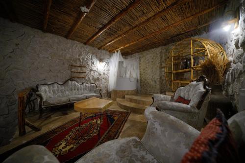 a living room with couches and a table at Cappadocia Nar Cave House & Swimming Pool in Nevsehir