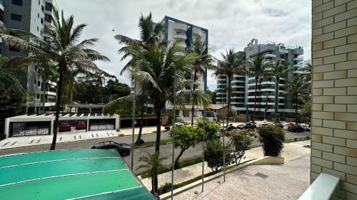 vistas a una ciudad con palmeras y edificios en Boulevard Riviera Flat en Bertioga