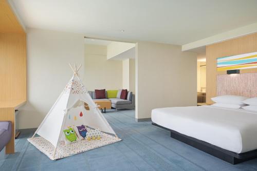 a bedroom with a bed and a play tent at Aloft Nanhai, Foshan in Nanhai