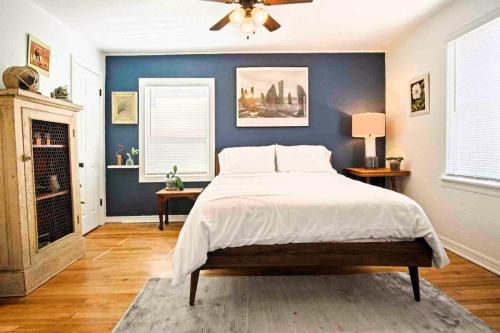 a bedroom with a bed and a blue wall at Stylish Farmhouse Retreat I 6 Min To Plaza Dist in Oklahoma City