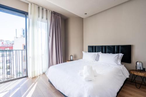 a bedroom with a white bed and a large window at TWENTY SIX ANFA LUXURY RESIDENCE by Shortstaymaroc -Hyper Centre -Parking in Casablanca