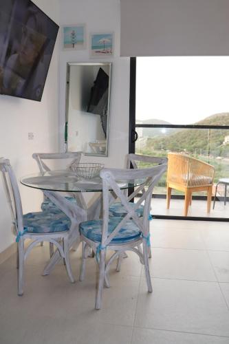 een eettafel en stoelen met een tafel en een spiegel bij APARTASUITE LUCIA SUN SET in Santa Marta