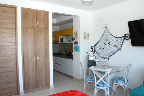 een keuken en eetkamer met een tafel en stoelen bij APARTASUITE LUCIA SUN SET in Santa Marta