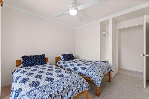 a bedroom with two beds and a ceiling fan at Lakesea Unit on Mort in Dalmeny