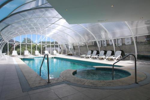 a swimming pool with chairs in a building at Costa Carilo Apart de Mar By HS in Carilo