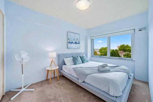 a bedroom with a bed and a window at Bridge View 2 Bed Apartment at Kirribilli in Sydney