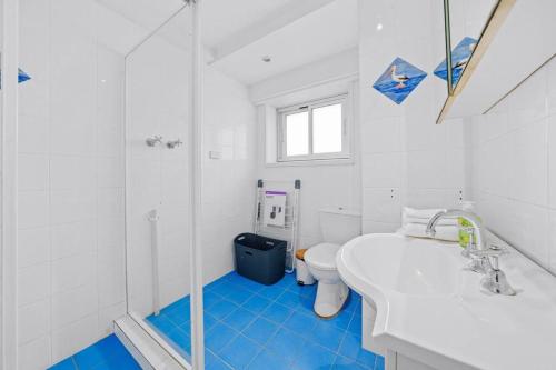 a white bathroom with a sink and a toilet at Bridge View 2 Bed Apartment at Kirribilli in Sydney