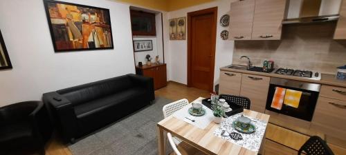 ein Wohnzimmer mit einem Tisch und einer Küche in der Unterkunft I Rifugi di Noah 2-Santa Maria a Vico- in Santa Maria a Vico