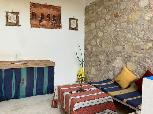a room with a stone wall and a table and chairs at Paradise Guest House in Agadir