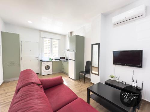 a living room with a red couch and a table at Apartamentos Blanco & Negro in Tarifa