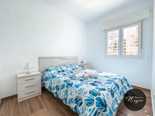 ein Schlafzimmer mit einem Bett, einer Kommode und einem Fenster in der Unterkunft Apartamentos Blanco & Negro in Tarifa