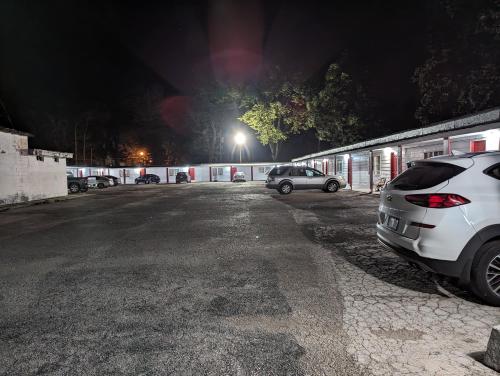 two cars parked in a parking lot at night at Sands Motel in Marianna