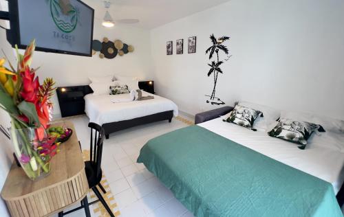 Cette chambre comprend 2 lits et une télévision. dans l'établissement Ti Coco Location - Manganao Saint-François avec Citerne Tampon Automatique, à Saint-François