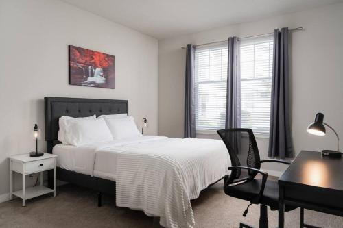 - une chambre avec un lit blanc, un bureau et une chaise dans l'établissement Luxurious 2BD2BA -WFH Equipped, à West Dundee