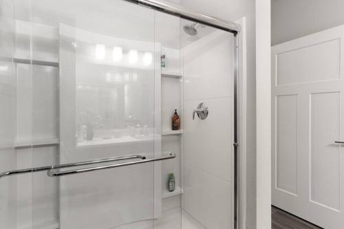 een douche met een glazen deur in de badkamer bij Luxurious 2BD2BA -WFH Equipped in West Dundee