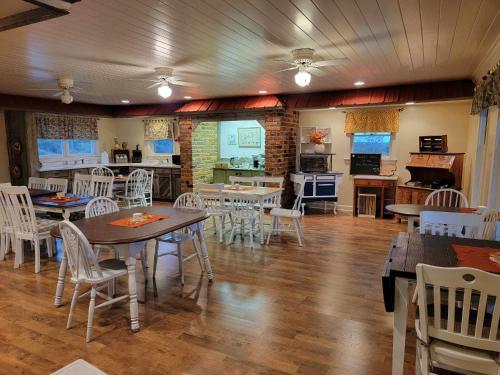 a dining room with tables and chairs and a kitchen at Moonlight Manor Bed & Breakfast in Floyd