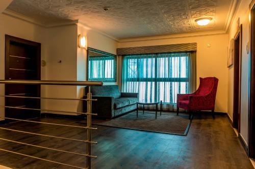 a living room with a couch and a chair at Protea Hotel by Marriott Lagos Kuramo Waters in Lagos