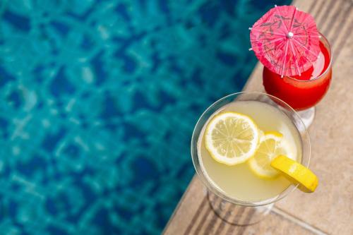 a drink with a lemon slice and a red drink at Protea Hotel by Marriott Lagos Kuramo Waters in Lagos
