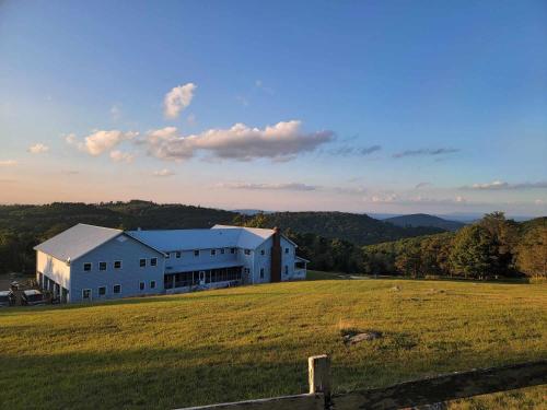 a large white building in a field with a fence at Moonlight Manor Bed & Breakfast in Floyd