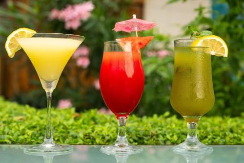 three cocktails sitting on top of a table at Protea Hotel by Marriott Lagos Kuramo Waters in Lagos