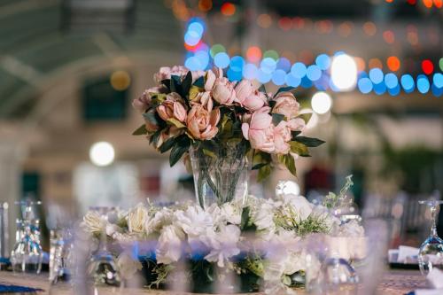 a vase filled with pink flowers on a table at Protea Hotel by Marriott Lagos Kuramo Waters in Lagos