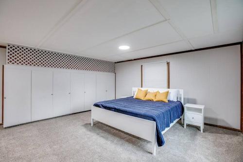 a bedroom with a bed with blue sheets and yellow pillows at Modern Cozy Home 4 min Drive from Notre Dame in South Bend