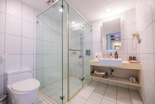 a bathroom with a shower and a toilet and a sink at Hotel Leisure Tamsui in Tamsui