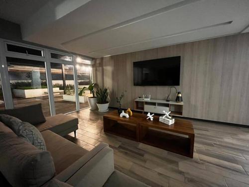 sala de estar con sofá y TV en Bonito Apartamento en zona exclusiva y tranquila, en Quetzaltenango
