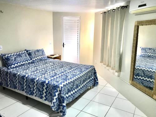 a bedroom with a blue and white bed and a mirror at Porto Dos Lençóis-Apt 12 in Barreirinhas