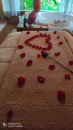 un montón de rosas rojas sobre una cama en Vila Paraíso en Blumenau