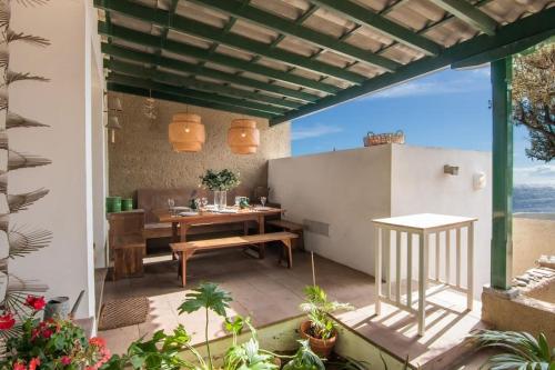 un patio extérieur avec une table en bois et une salle à manger dans l'établissement Villa El Olivo - first line with direct access to the beach, à Poris de Abona