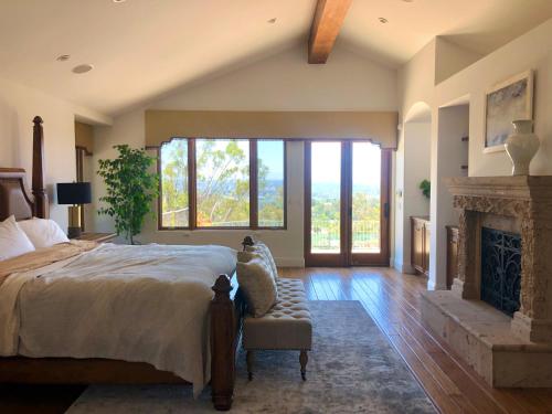ein Schlafzimmer mit einem großen Bett und einem Kamin in der Unterkunft Celebrity Dream Estate in Rancho Santa Fe