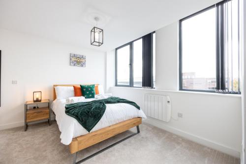 Chic Luxury Apartment near Old Trafford Stadiums Manchester في مانشستر: غرفة نوم بسرير ونوافذ كبيرة