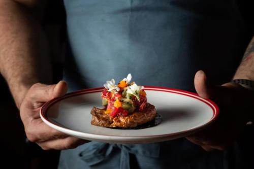 a person holding a plate with food on it at Hotel Indigo Sydney Potts Point by IHG in Sydney