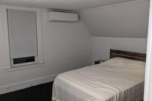 a white bedroom with a bed and a window at Bangor home minutes from airport in Bangor